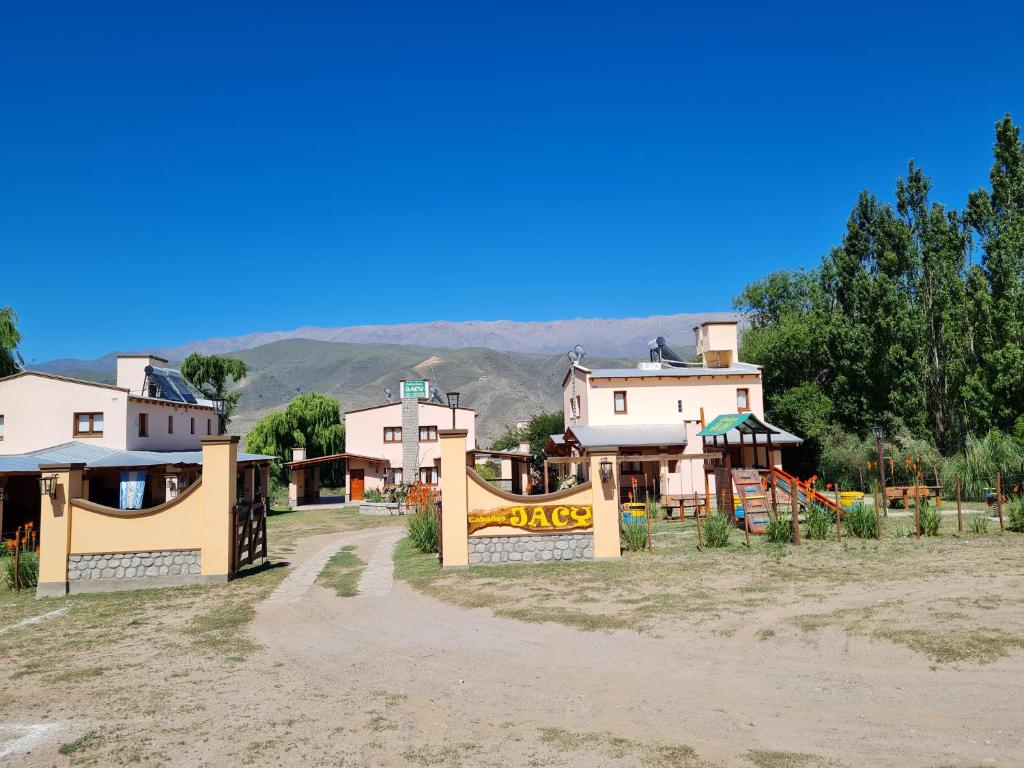 un groupe de maisons avec une aire de jeux en face dans l'établissement Cabañas Jacy, à Tafí del Valle