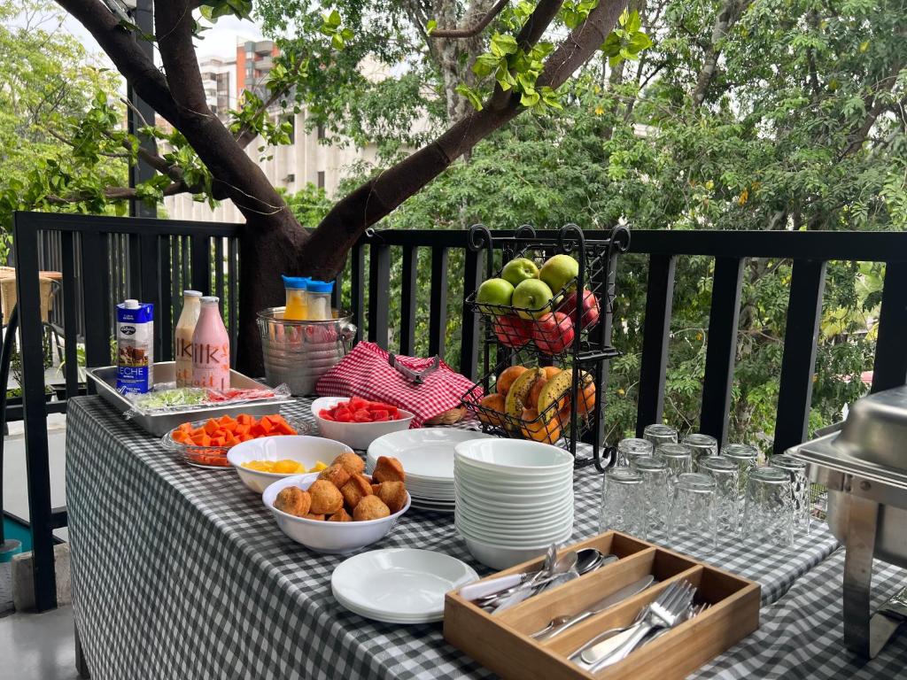 a table topped with plates and bowls of food at HOTEL 9.5 SAN FERNANDO in Cali