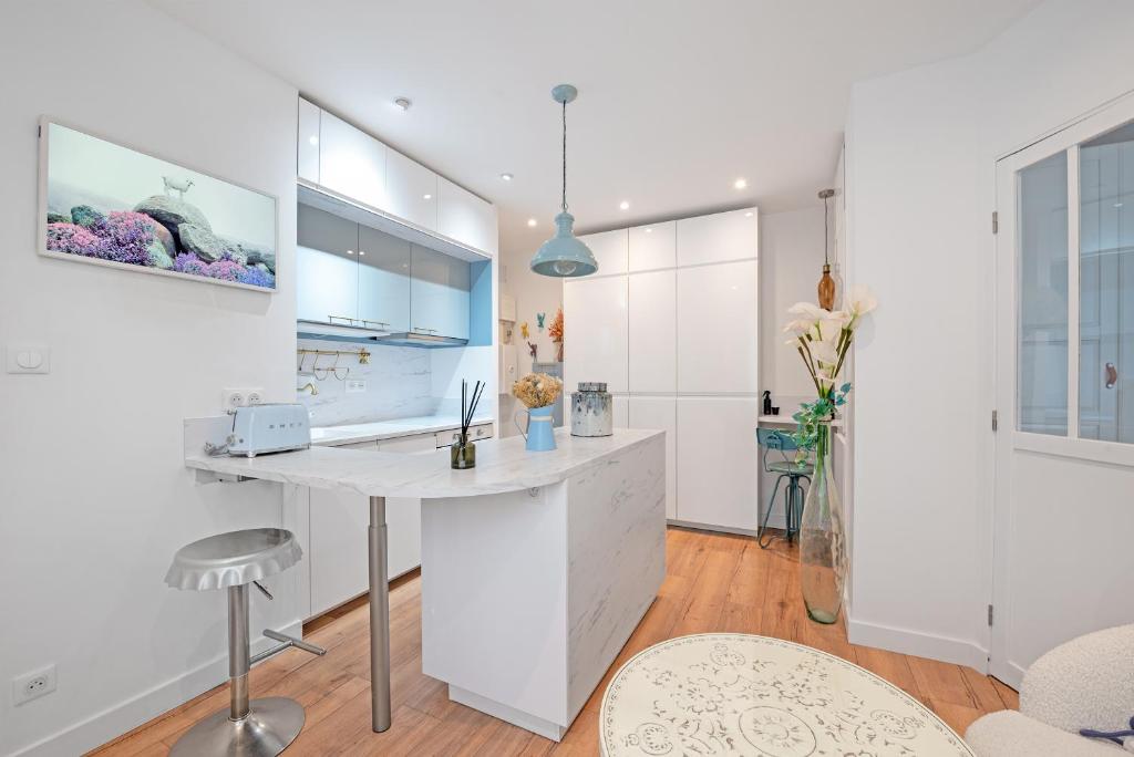 a kitchen with a white counter and a desk at Le Sapphire in Toulouse