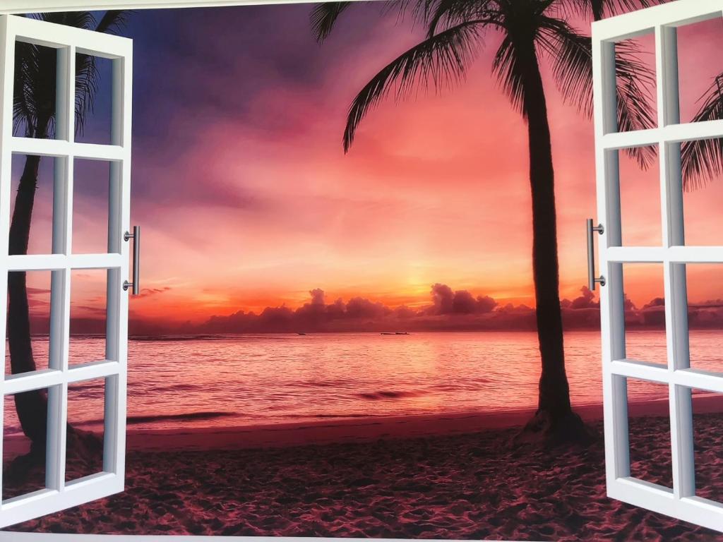 una ventana abierta a una playa tropical con puesta de sol en senahahausub03 en Yomitan