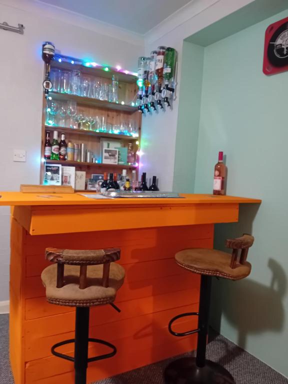 a bar with two stools in a room at Sea Air B&B in Chapel Saint Leonards
