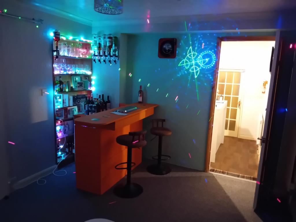 a bar in a room with a blue wall at Sea Air B&B in Chapel Saint Leonards