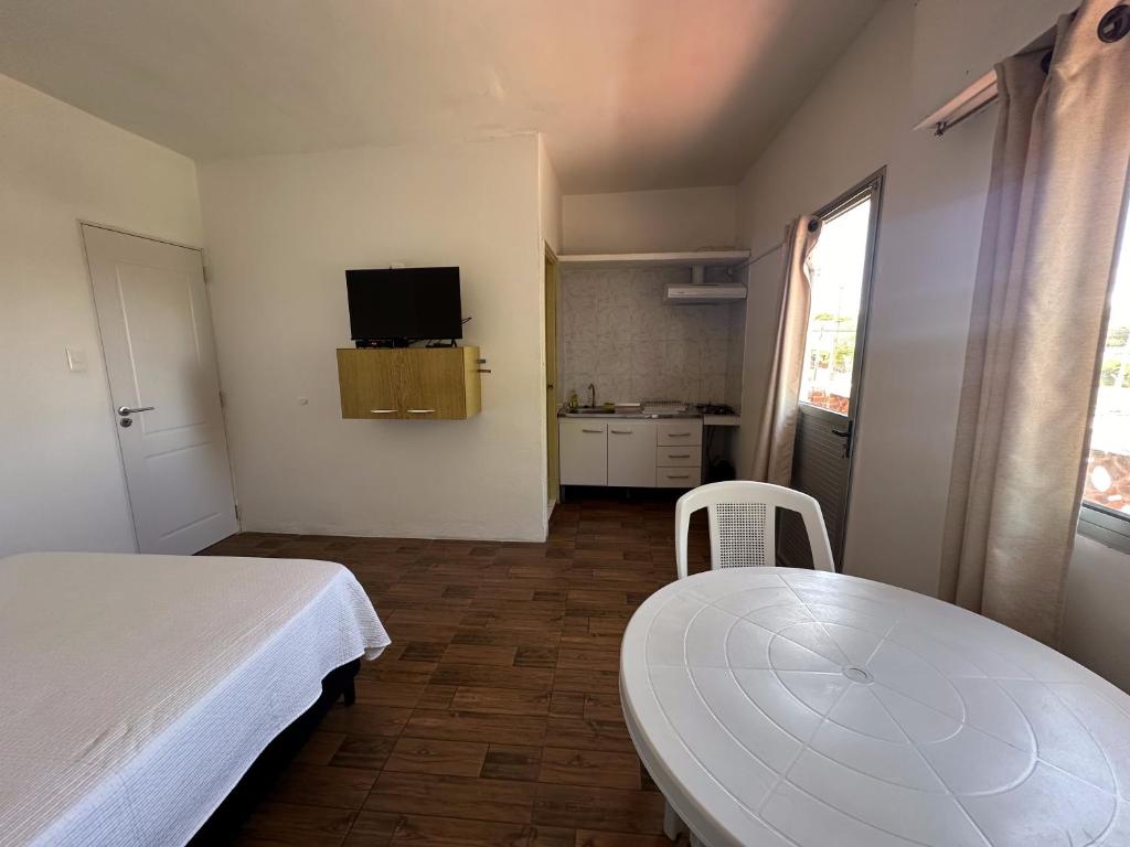 Habitación con cama, mesa y cocina. en Departamentos LT1 en Las Toscas
