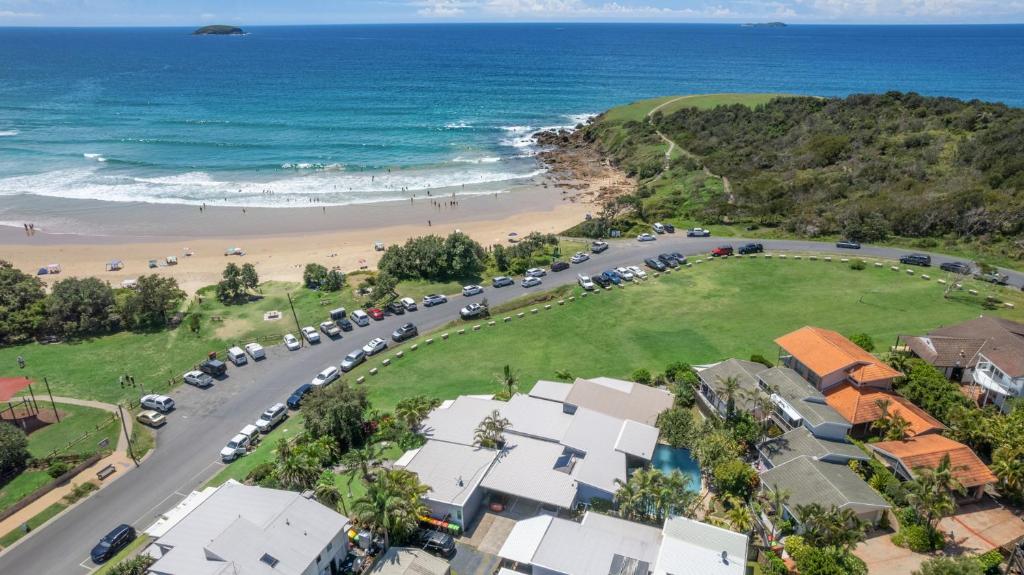 una vista aérea de una playa con coches aparcados en ArtHOUSE Beachfront Accommodation, en Emerald Beach