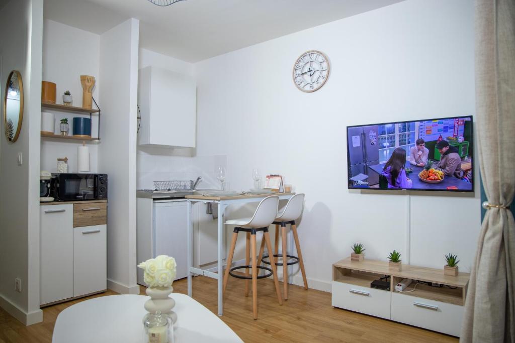 a small kitchen with a table and a counter top at Le Beverley Studio in Blain