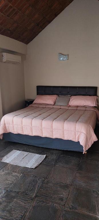 a bedroom with a bed with pink sheets on it at La Clarita , hospedaje boutique de descanso in Francisco Álvarez