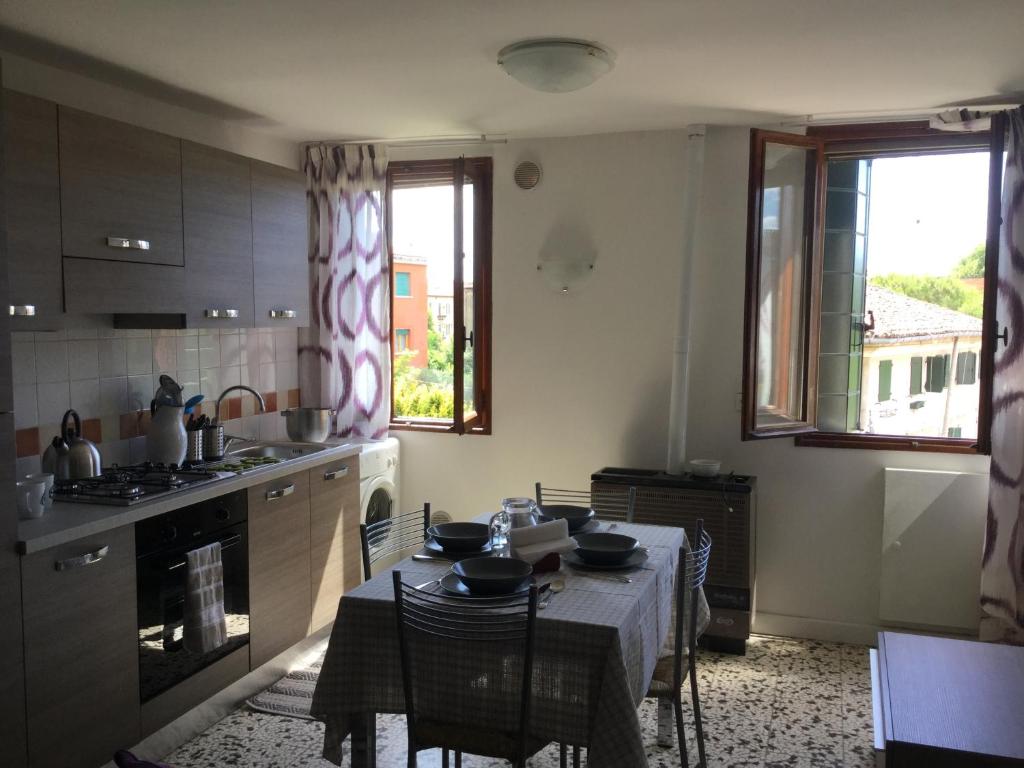 una cucina con tavolo e una cucina con tavolo e sedie di Casa Annalisa a Venezia