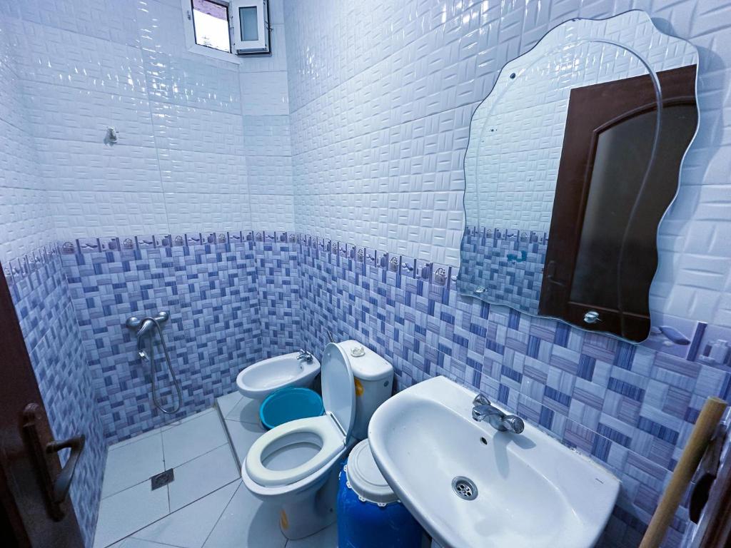La salle de bains bleue et blanche est pourvue de toilettes et d'un lavabo. dans l'établissement Appartement el hichou 1, à Ksar Sghir