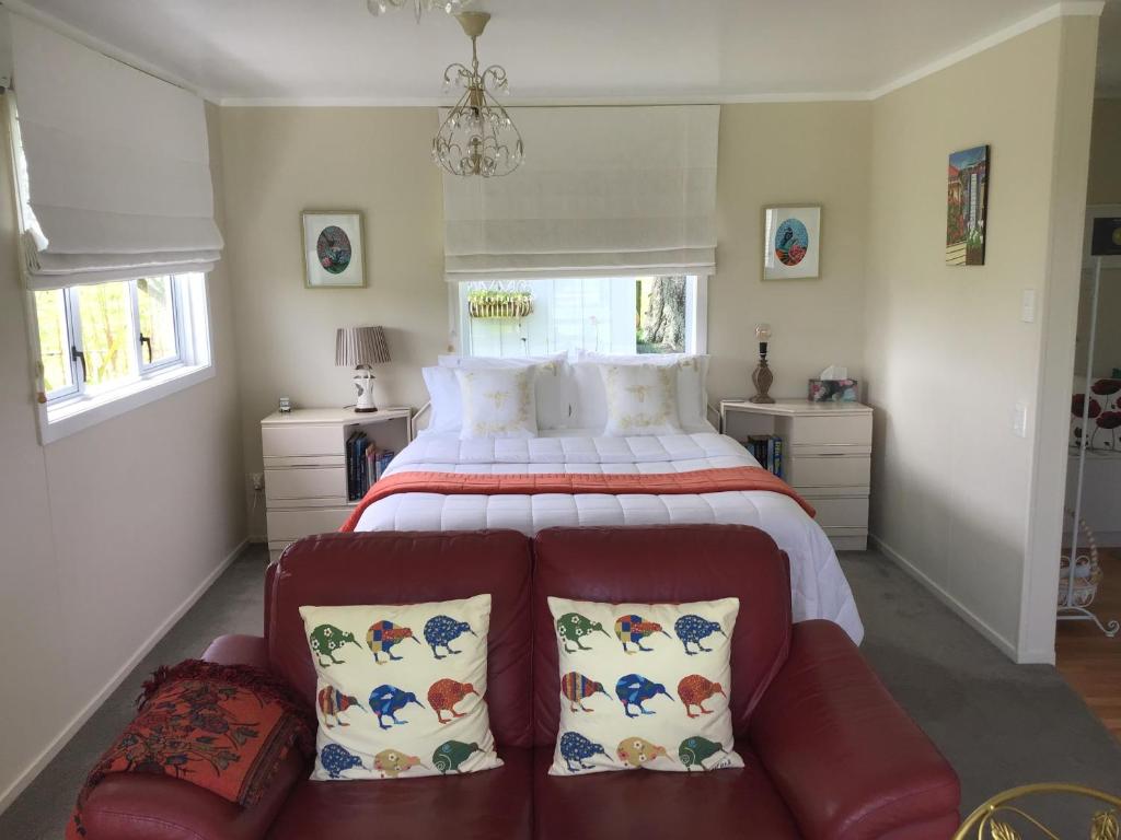 a bedroom with a large bed and a couch at Mohaonui Farmstay in Otorohanga