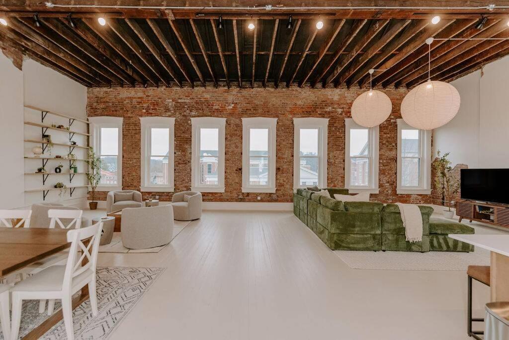 a living room with white floors and a brick wall at East Main Lofts - Roller Rink 301 in Madison