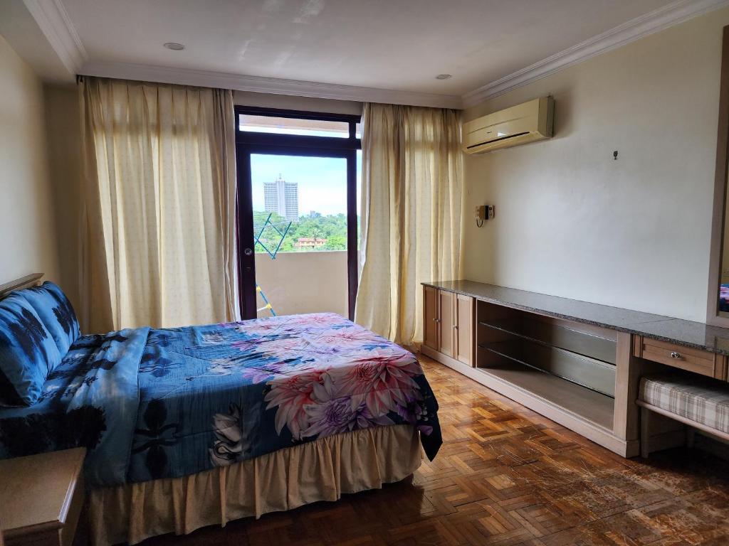 een slaapkamer met een bed en een groot raam bij Riverbank Suites Kuching Waterfront in Kuching