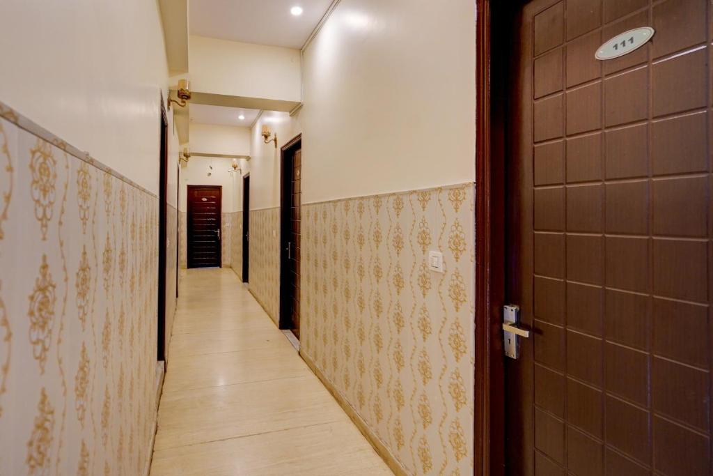 um corredor vazio com um longo corredor com uma porta em Capital O Hotel Shimaya em Mājra