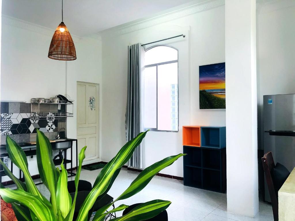 a living room with a potted plant and a window at Gem Villa 67, biệt thự 15 phòng có hồ bơi lớn in Ho Chi Minh City