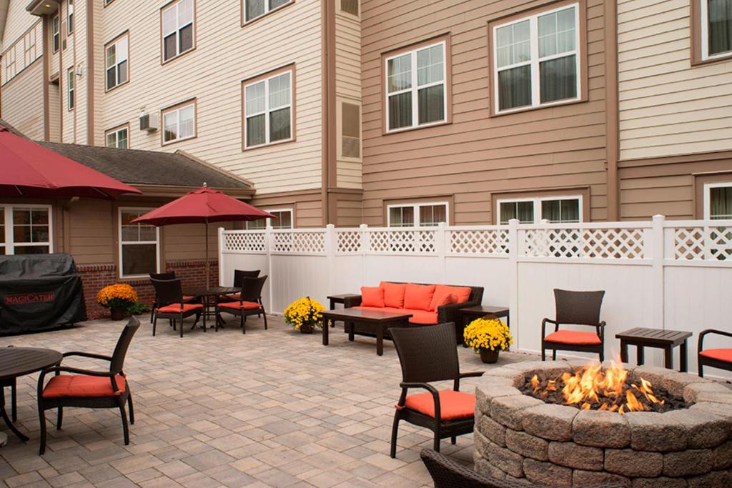 patio z miejscem na ognisko, stołami i krzesłami w obiekcie Residence Inn by Marriott Saratoga Springs w mieście Saratoga Springs