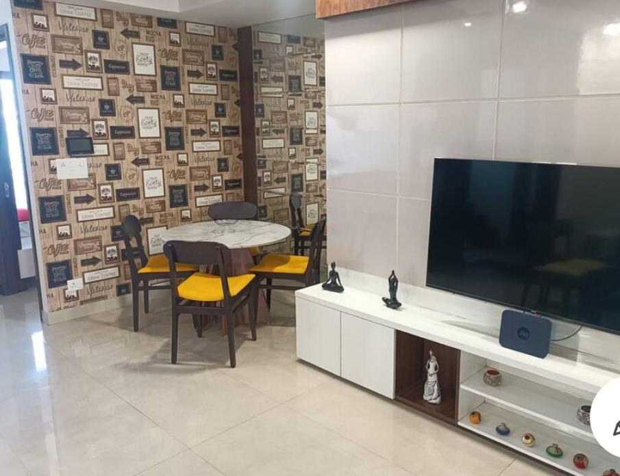 a living room with a table and a television and a table and chairs at City Beautiful Home Double Room Suite in Panchkula