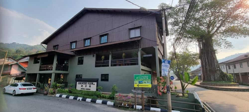 a white car parked in front of a building at Country View Inn in Sungai Lembing
