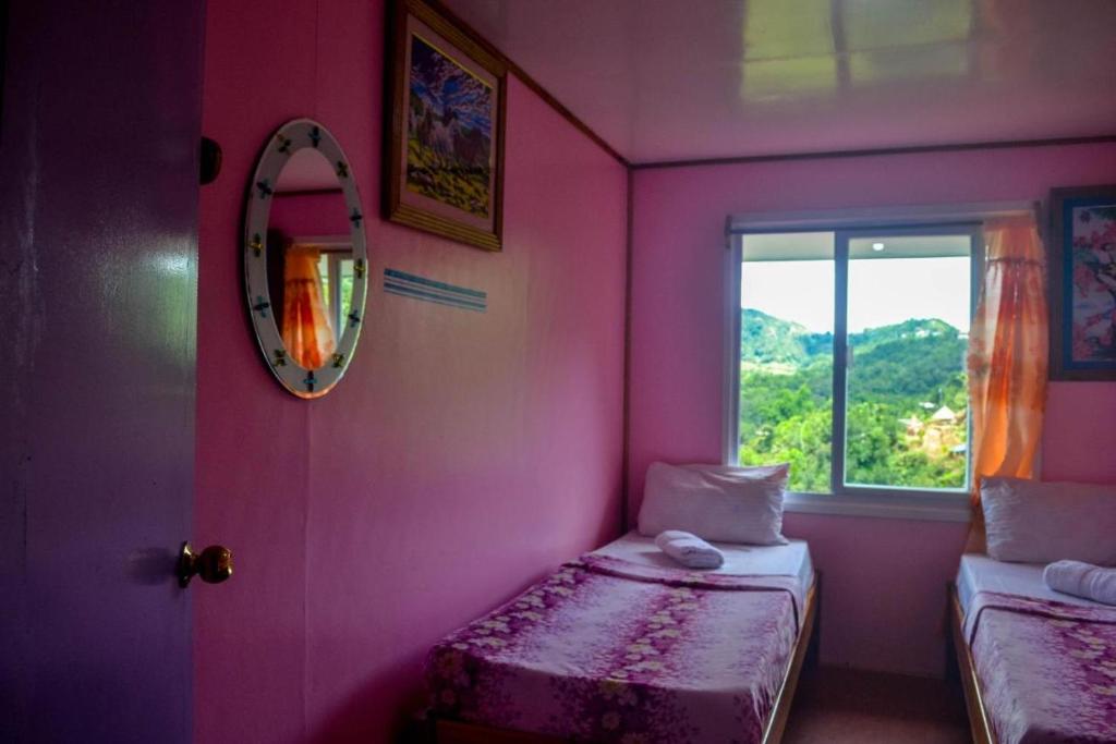 Postel nebo postele na pokoji v ubytování BANAUE EVERGREEN HOSTEL AND RESTAURANT
