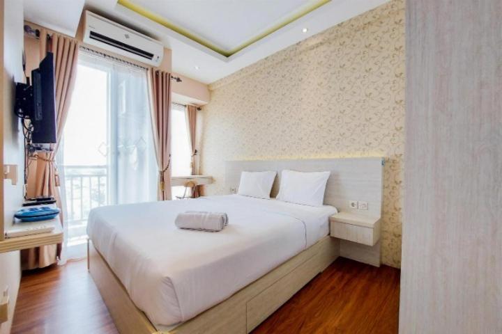 uma grande cama branca num quarto com uma janela em comfy corner studio apartment em Ciater-hilir