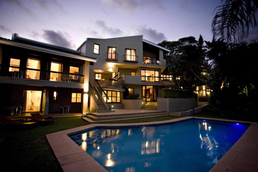 a large house with a swimming pool in front of it at Teremok Lodge & Spa in Durban