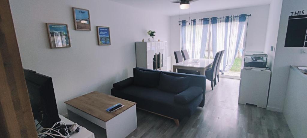 un salon avec un canapé et une table dans l'établissement Maison familiale proche plage et commerces, à Saint-Nazaire