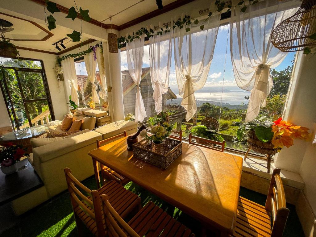 ein Wohnzimmer mit einem Tisch und einem großen Fenster in der Unterkunft The Breeze View Lodge - Tagaytay in Ulot