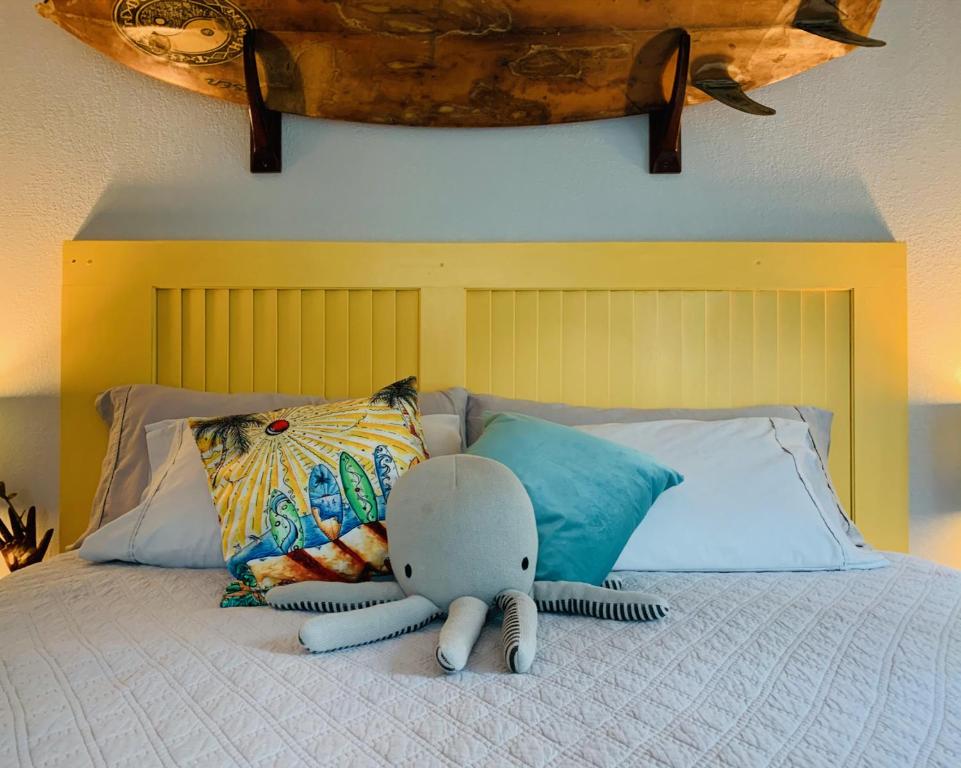 ein Bett mit einem ausgestopften Elefanten, der darauf liegt in der Unterkunft Puolani Iki-Sweet lil cottage near National Park in Volcano