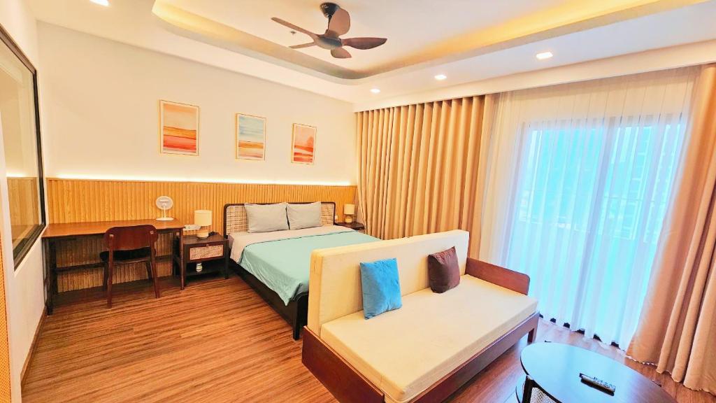 een slaapkamer met een bed, een bureau en een bank bij FLC SEA TOWER QUY NHƠN Ưu Đãi Khủng Ngay Hôm Nay in Quy Nhon
