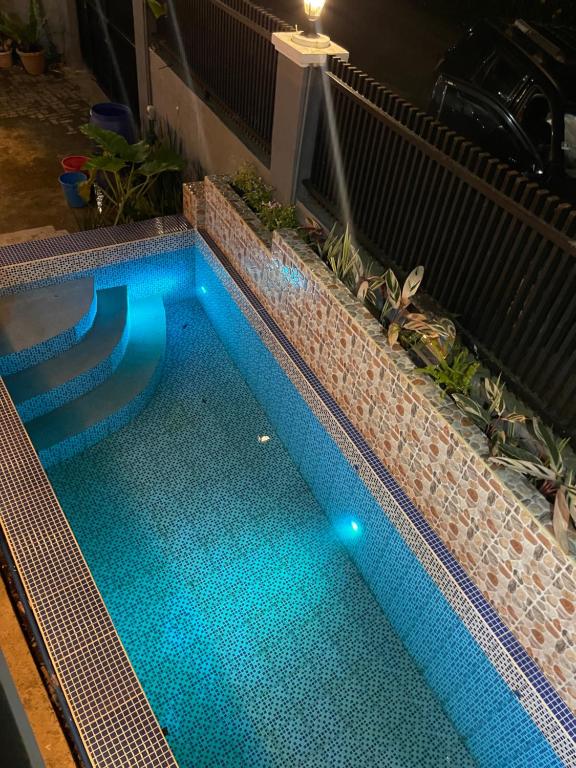 una piscina con luces azules en una casa en Sky Rancho Hostel en Tagaytay
