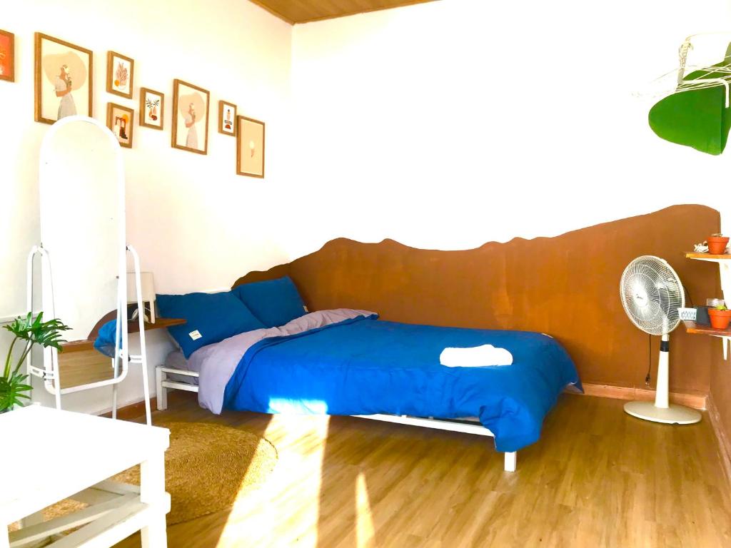 een slaapkamer met een bed met blauwe lakens en een ventilator bij Abahi homestay (giá rẻ ) in Xuan An
