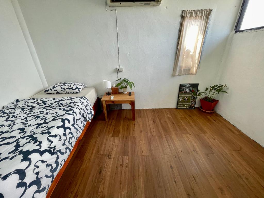 1 dormitorio con 1 cama y suelo de madera en Budget Accommodation Koh Phangan Pier en Ko Phangan