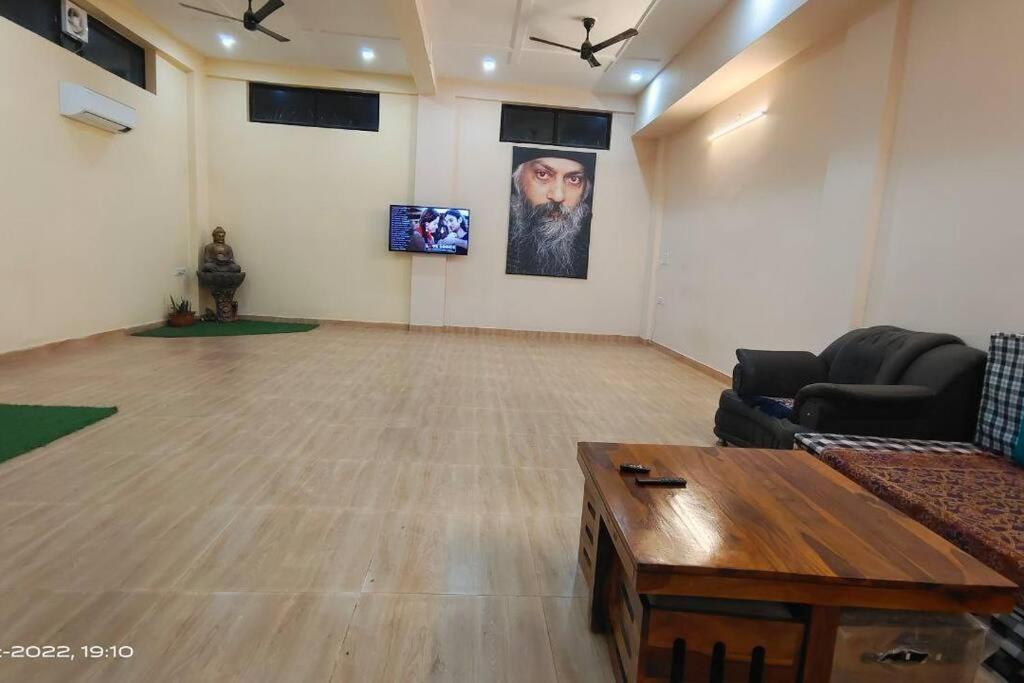 een woonkamer met een bank en een tafel bij OSHO Villa, Party Hall & AC dormitory Near Airport in Jaipur