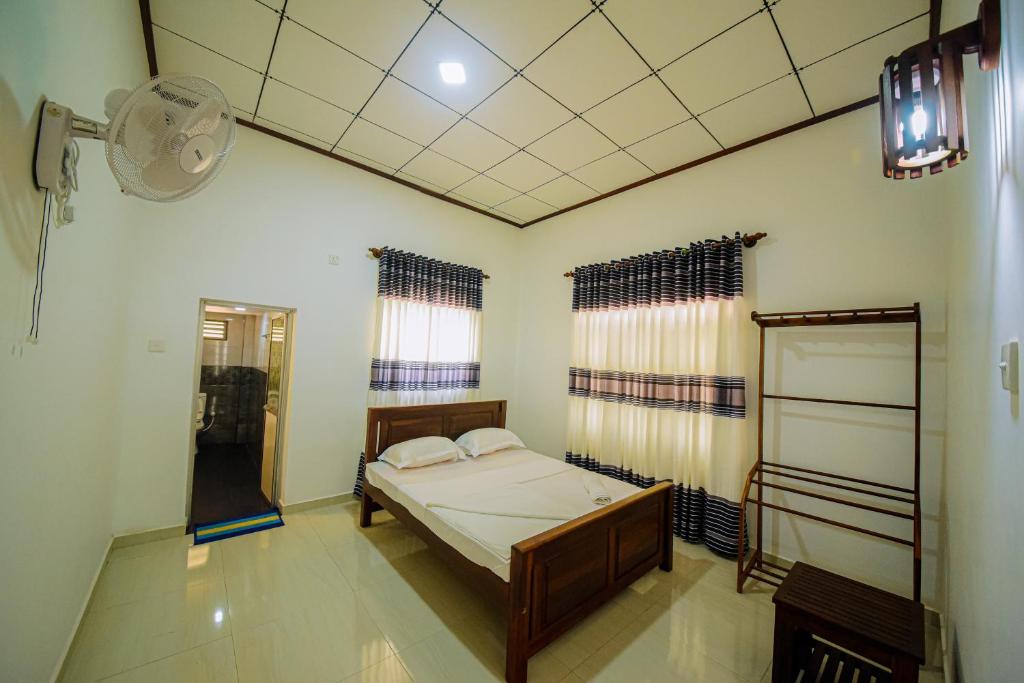um quarto com uma cama, uma janela e uma ventoinha em Mondial Dream Resort em Wellawaya