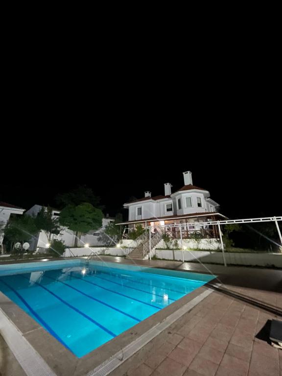 a swimming pool in front of a house at night at VILLA in Tekirdag- Istanbul in Tekirdag