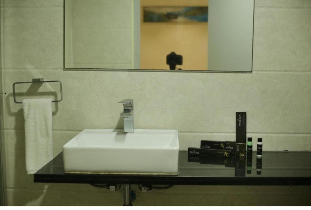 a bathroom counter with a sink and a mirror at Hotel Raj vihar residency in Vijayawāda