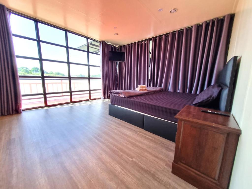 a bedroom with a bed and a tv in a room at แพรุ่งธารา ไชโย (Rungtara Houseboats) in Ban Bang Sala