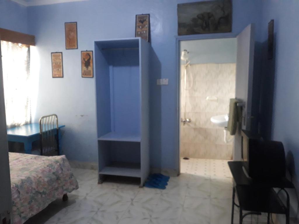 a blue room with a bed and a bathroom at RockVilla GuestHouse Njabini in South Kinangop