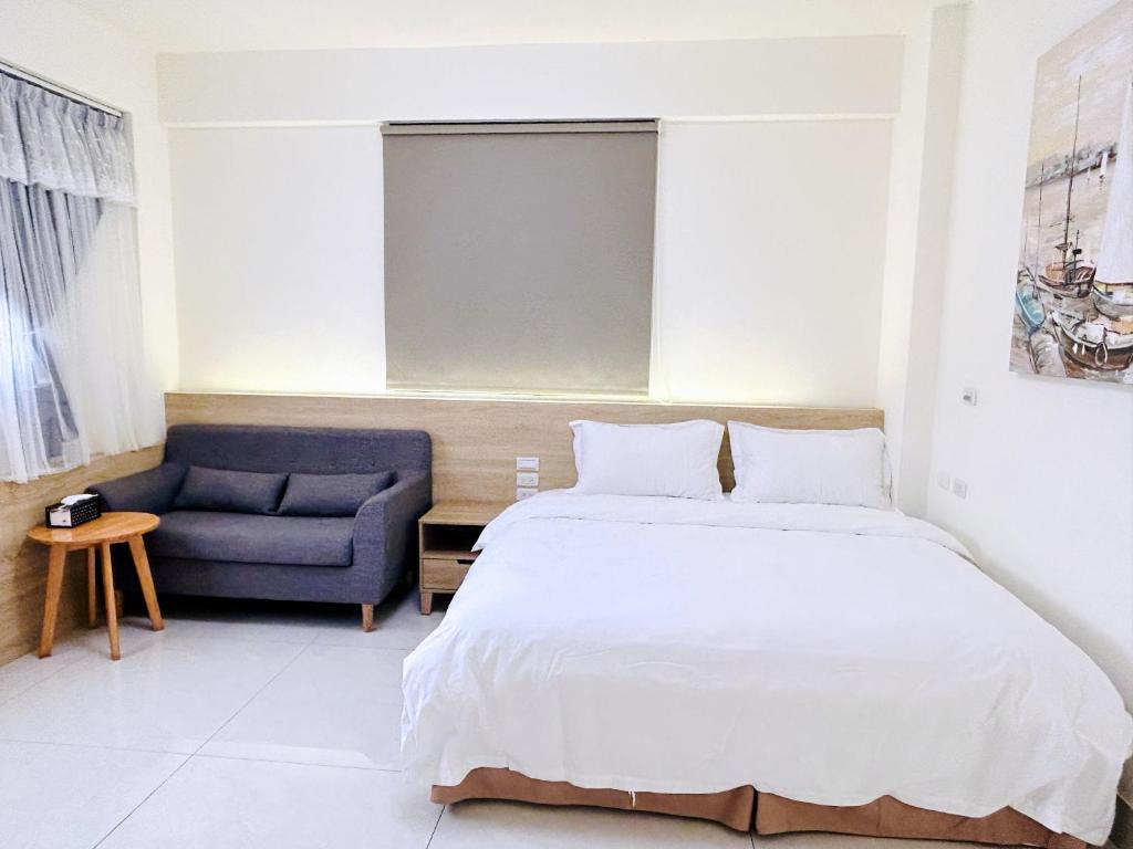 a bedroom with a bed and a blue couch at 里舍民宿 in Jincheng