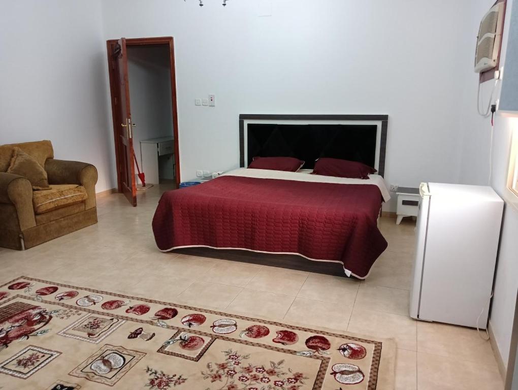Soma Suites في المدينة المنورة: غرفة نوم بسرير كبير مع بطانية حمراء