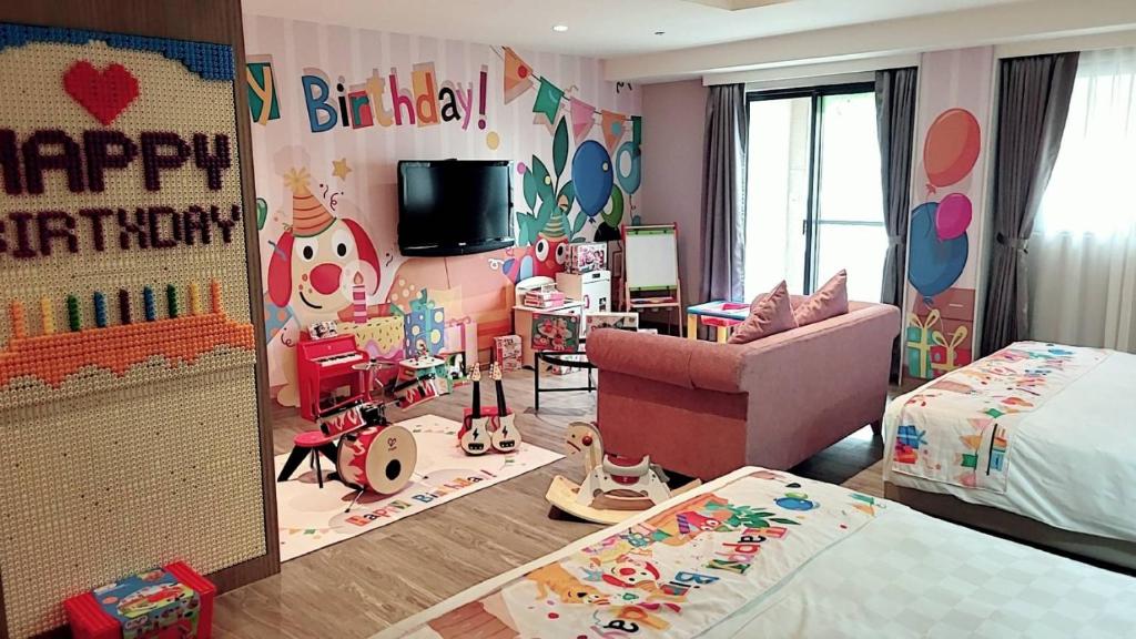 a childs room with a happy birthday sign and a bedroom at E-DA Skylark Hotel in Dashu