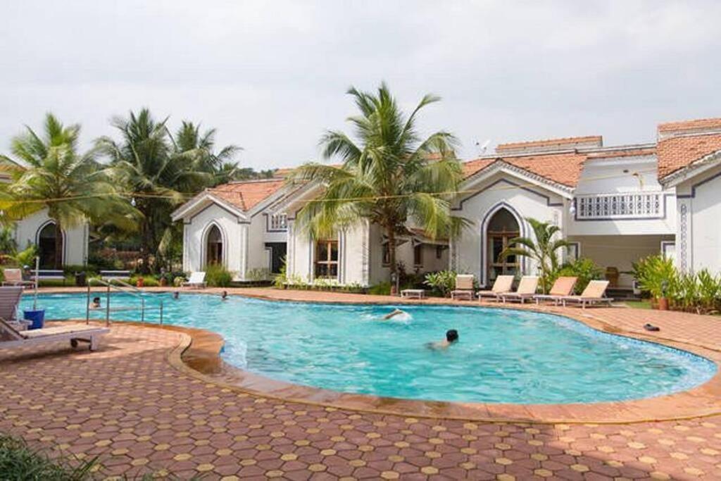 a person swimming in a swimming pool in a house at Riviera Hermitage in Arpora