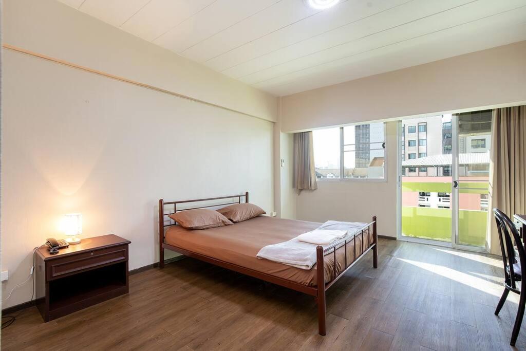 una camera con un letto e una grande finestra di Spacious BKK studio hi speed WiFi downtown a Bangkok