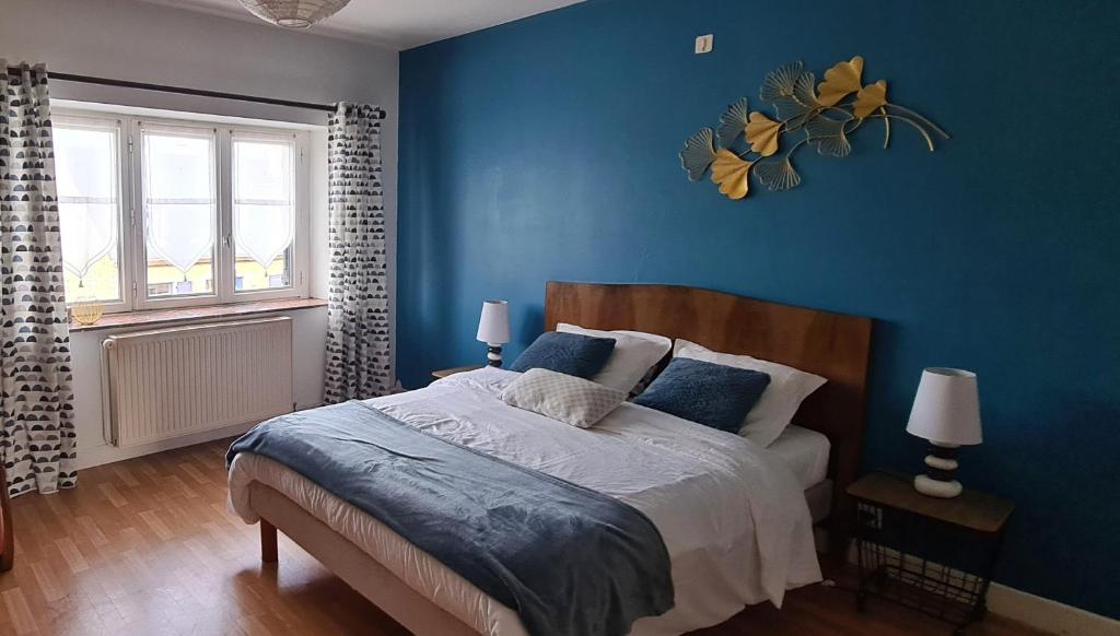 1 dormitorio con paredes azules y 1 cama con almohadas azules en Ancienne Fermette le Charlemont Givet Foisches, en Foisches