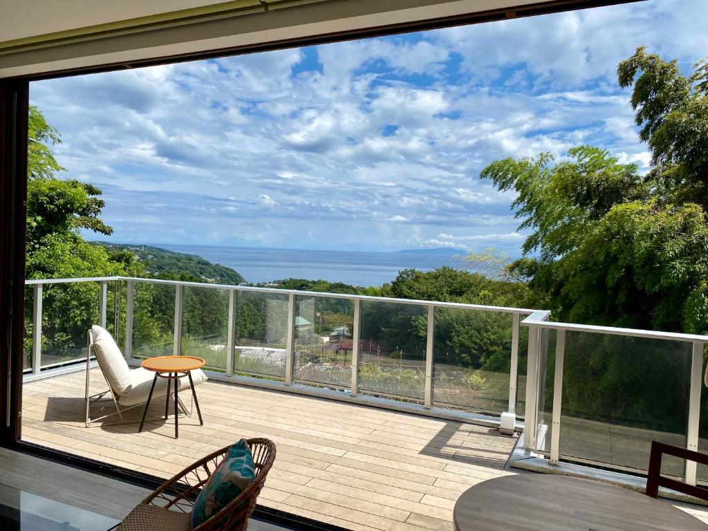 a balcony with a view of the ocean at Yugawara Vacation House in Yugawara