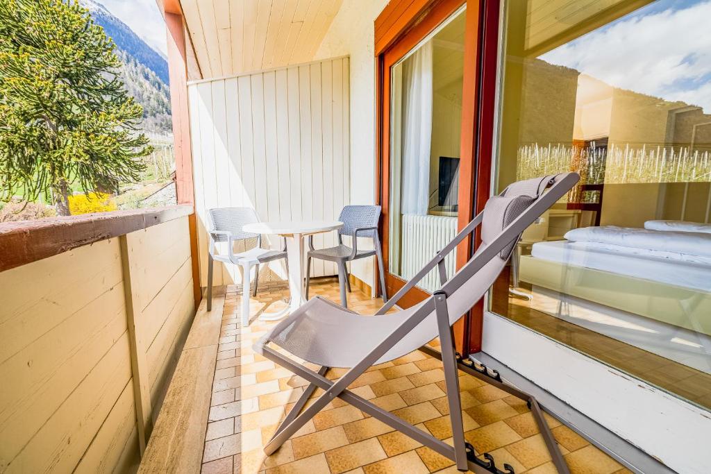 a room with a balcony with a table and chairs at Wanda Apartments in Parcines