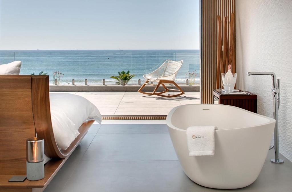 uma casa de banho com banheira e vista para o oceano em Villa Miramar Frontignan em Frontignan