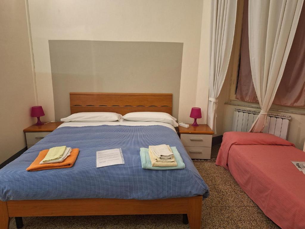 1 dormitorio con 1 cama con 2 toallas en Guest House Erika, en La Spezia