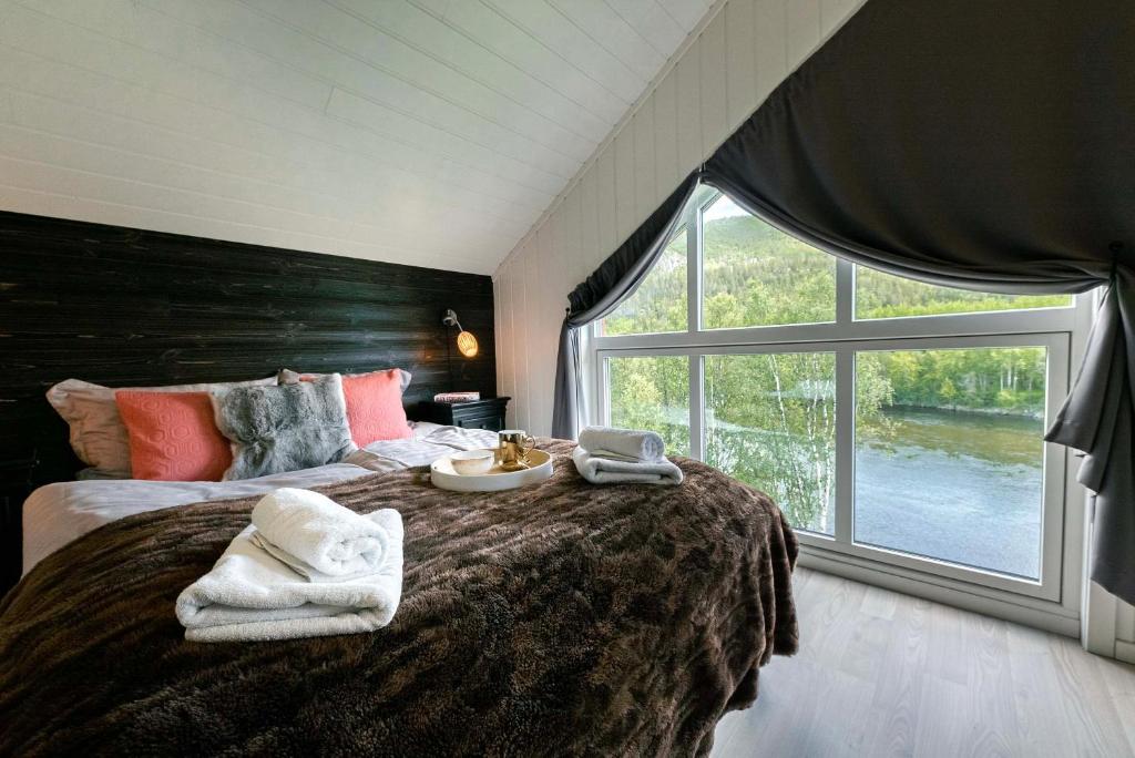 um quarto com uma cama grande e toalhas em Reisa Lodge em Storslett