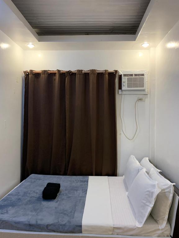 a bedroom with a bed and a air conditioner at Dadods homestay in General Luna
