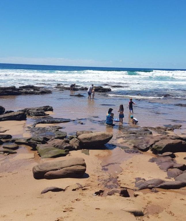a group of people playing in the water on a beach at Sunshine Cottage in Pennington