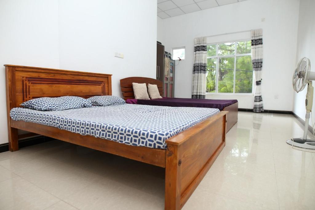 una camera con letto in legno di Lovely 2 Bedroom Apartment (With Bathroom& Kitchen) a Anuradhapura